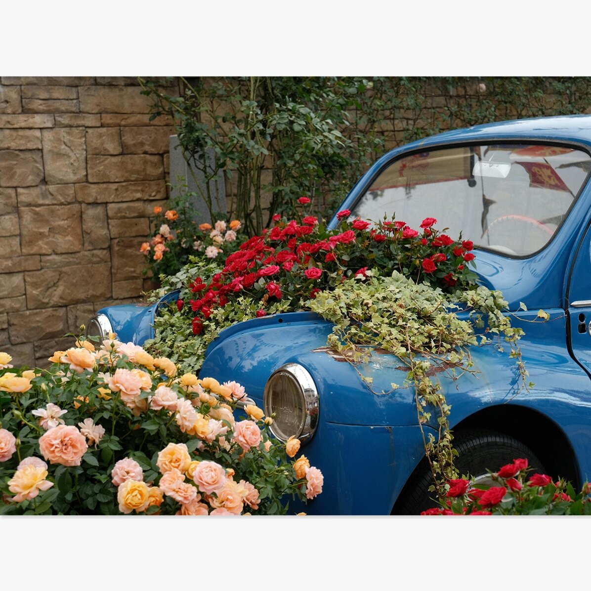 Póster de un coche azul vintage con flores
