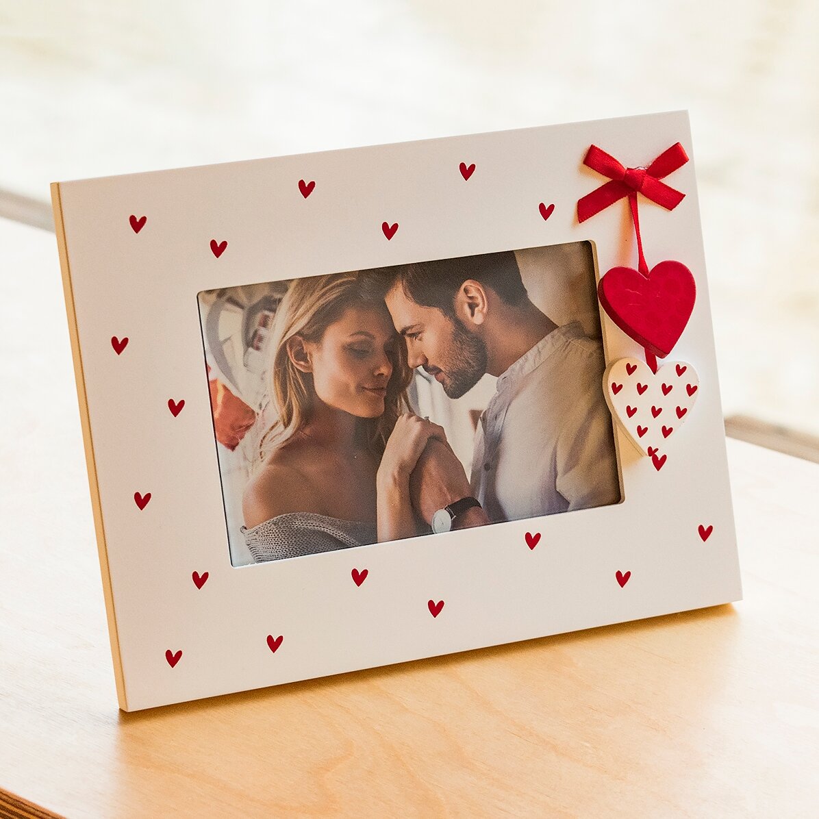 Marco de fotos de escritorio con corazoncitos y un lazo rojo, para una foto
